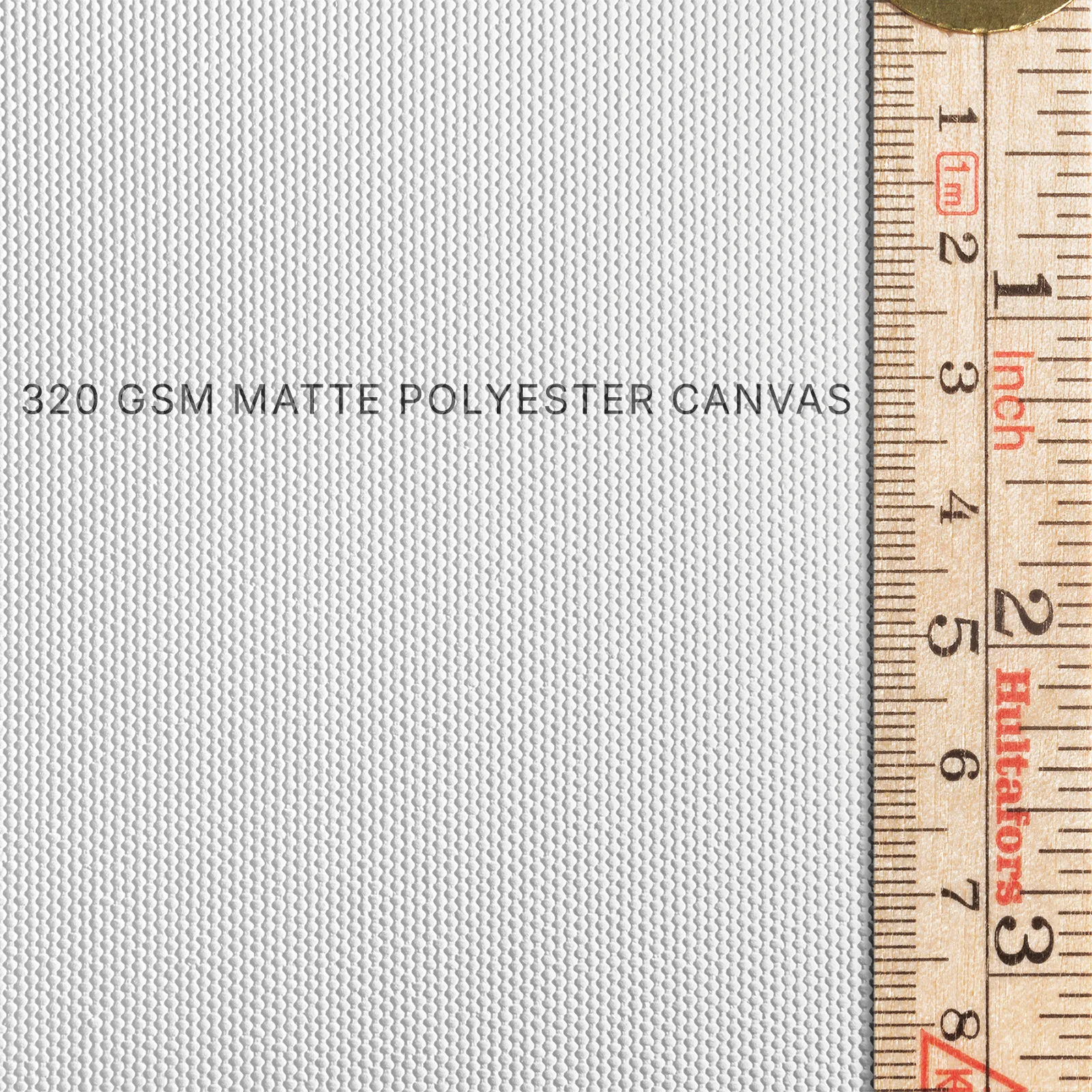 Close-up of 320 GSM matte polyester canvas texture with ruler for thickness reference